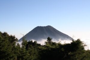 The National Parks Of El Salvador A volcano rises above the fog and trees.
